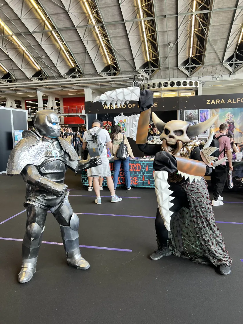 My Karn cosplay facing off against a Grist cosplayer wearing a horned skull mask.
